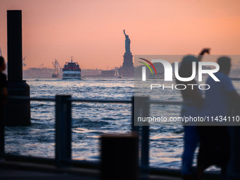  Sunset over the East River and a view on the Statue of Liberty in New York City, United States of America on July 7th, 2024.  (