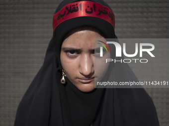 A young veiled Iranian schoolgirl is wearing a religious headband with Persian script that reads, ''Daughters of the Revolution,'' while par...