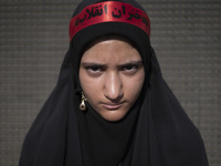 A young veiled Iranian schoolgirl is wearing a religious headband with Persian script that reads, ''Daughters of the Revolution,'' while par...