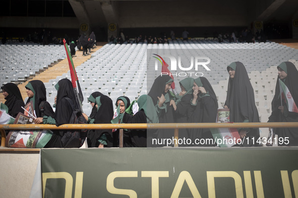 Young veiled schoolgirls are arriving to participate in a gathering to support mandatory hijab at the Azadi (Freedom) Stadium in western Teh...