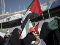 Young veiled schoolgirls are carrying an Iranian flag and a Palestinian flag while arriving to participate in a gathering to support mandato...