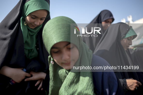 Young veiled schoolgirls are arriving to participate in a gathering to support mandatory hijab at the Azadi (Freedom) Stadium in western Teh...