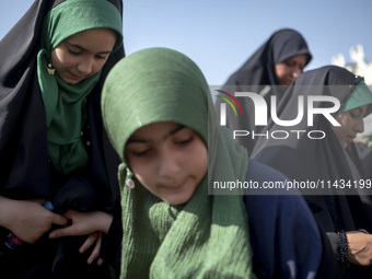 Young veiled schoolgirls are arriving to participate in a gathering to support mandatory hijab at the Azadi (Freedom) Stadium in western Teh...