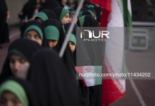 A young veiled Iranian schoolgirl is looking on while participating in a gathering to support mandatory hijab at the Azadi (Freedom) Stadium...