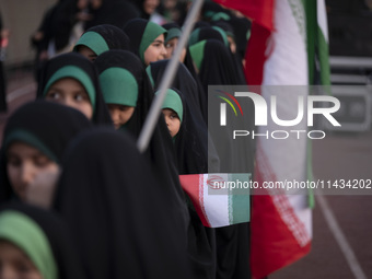 A young veiled Iranian schoolgirl is looking on while participating in a gathering to support mandatory hijab at the Azadi (Freedom) Stadium...