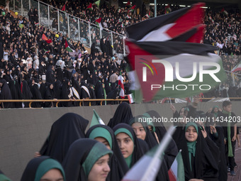 Young veiled Iranian schoolgirls are waving Palestinian flags while participating in a gathering to support the mandatory hijab at the Azadi...