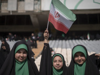 A young veiled schoolgirl is waving an Iranian flag while participating in a gathering to support mandatory hijab at the Azadi (Freedom) Sta...