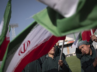 Young schoolboys are waving Iranian flags while participating in a gathering to support mandatory hijab at the Azadi (Freedom) Stadium in we...