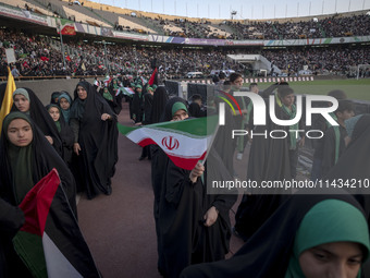 A young veiled schoolgirl is waving an Iranian flag while participating in a gathering to support mandatory hijab at the Azadi (Freedom) Sta...