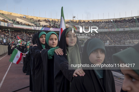 Young veiled Iranian schoolgirls are standing in military formation, while participating in a gathering to support the mandatory hijab at th...