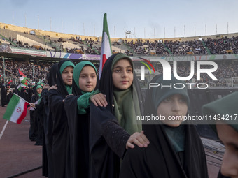 Young veiled Iranian schoolgirls are standing in military formation, while participating in a gathering to support the mandatory hijab at th...