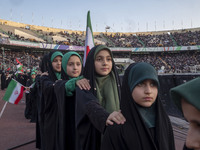 Young veiled Iranian schoolgirls are standing in military formation, while participating in a gathering to support the mandatory hijab at th...