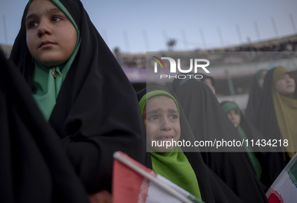 A young veiled Iranian schoolgirl is crying as a reaction to a religious song while participating in a gathering to support mandatory hijab...