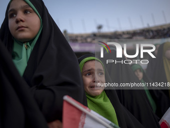 A young veiled Iranian schoolgirl is crying as a reaction to a religious song while participating in a gathering to support mandatory hijab...