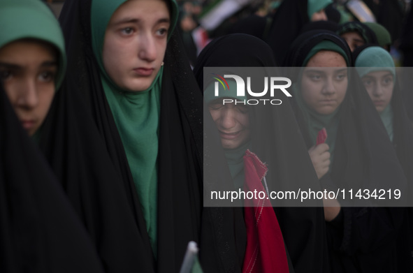 A young veiled Iranian schoolgirl is crying as a reaction to a religious song while participating in a gathering to support mandatory hijab...