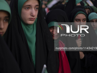 A young veiled Iranian schoolgirl is crying as a reaction to a religious song while participating in a gathering to support mandatory hijab...