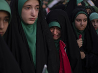 A young veiled Iranian schoolgirl is crying as a reaction to a religious song while participating in a gathering to support mandatory hijab...