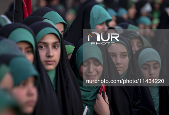 A young veiled Iranian schoolgirl is crying as a reaction to a religious song while participating in a gathering to support mandatory hijab...