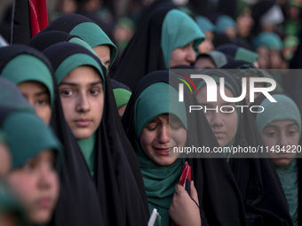 A young veiled Iranian schoolgirl is crying as a reaction to a religious song while participating in a gathering to support mandatory hijab...