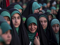 A young veiled Iranian schoolgirl is crying as a reaction to a religious song while participating in a gathering to support mandatory hijab...