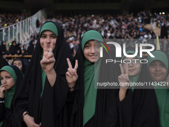 Young veiled Iranian schoolgirls are flashing Victory signs while participating in a gathering to support mandatory hijab at the Azadi (Free...