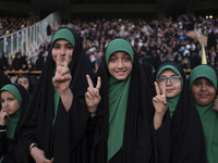 Young veiled Iranian schoolgirls are flashing Victory signs while participating in a gathering to support mandatory hijab at the Azadi (Free...