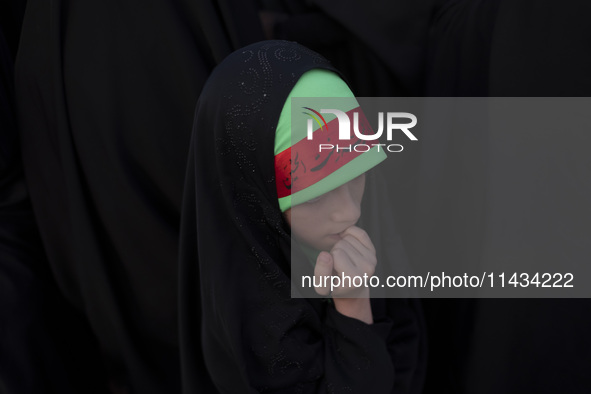 A young veiled Iranian schoolgirl is wearing a religious headband while participating in a gathering to support mandatory hijab at the Azadi...