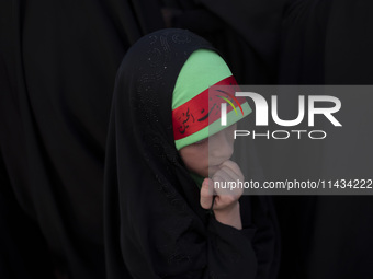 A young veiled Iranian schoolgirl is wearing a religious headband while participating in a gathering to support mandatory hijab at the Azadi...