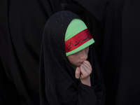 A young veiled Iranian schoolgirl is wearing a religious headband while participating in a gathering to support mandatory hijab at the Azadi...