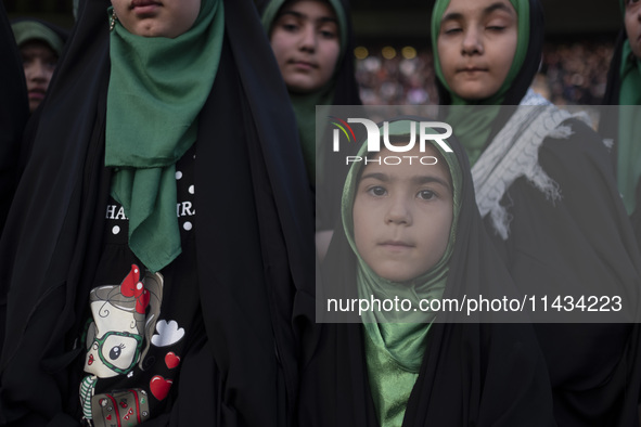 A young veiled Iranian schoolgirl is looking on while participating in a gathering to support mandatory hijab at the Azadi (Freedom) Stadium...