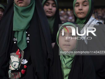 A young veiled Iranian schoolgirl is looking on while participating in a gathering to support mandatory hijab at the Azadi (Freedom) Stadium...