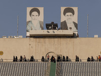 Veiled Iranian women are walking under portraits of Iran's Late Leader, Ayatollah Ruhollah Khomeini (L), and Supreme Leader, Ayatollah Ali K...