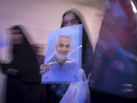 A veiled Iranian woman is carrying a portrait of former commander of the Islamic Revolutionary Guard Corps' (IRGC) Quds Force, Major General...