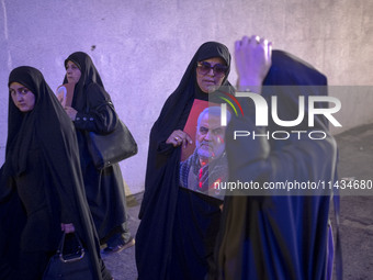 A veiled Iranian woman is carrying a portrait of former commander of the Islamic Revolutionary Guard Corps' (IRGC) Quds Force, Major General...