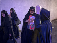 A veiled Iranian woman is carrying a portrait of former commander of the Islamic Revolutionary Guard Corps' (IRGC) Quds Force, Major General...