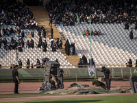 Two security personnel are searching an area with dogs before the beginning of a family rally to support mandatory hijab, at the Azadi (Free...