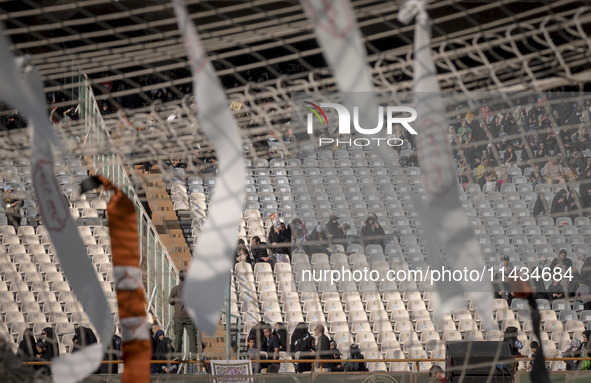 Religious headbands are being tied on a soccer goal, while veiled Iranian women are participating in a family rally to support mandatory hij...