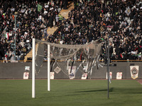 Religious headbands are being tied on a soccer goal, while veiled Iranian women are participating in a family rally to support mandatory hij...