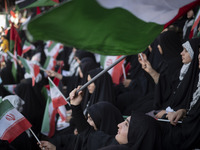 A young veiled Iranian woman is waving a Palestinian flag while participating in a family rally to support mandatory hijab, at the Azadi (Fr...