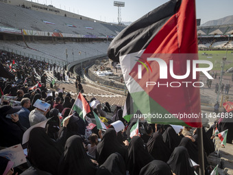 A young veiled Iranian woman (not pictured) is waving a Palestinian flag while participating in a family rally to support mandatory hijab, a...