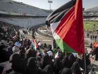 A young veiled Iranian woman (not pictured) is waving a Palestinian flag while participating in a family rally to support mandatory hijab, a...