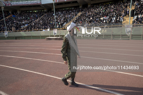 An Iranian cleric is looking at veiled women who are participating in a family rally to support mandatory hijab, at the Azadi (Freedom) Stad...