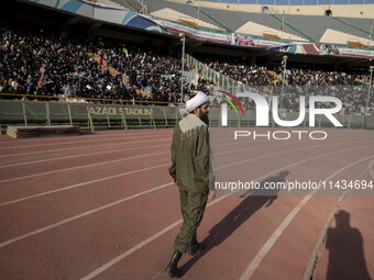 An Iranian cleric is walking along an area while veiled Iranian women are participating in a family rally to support mandatory hijab at the...