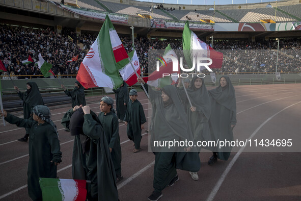 A group of young veiled women is waving Iranian flags while performing in a family rally to support mandatory hijab, at the Azadi (Freedom)...