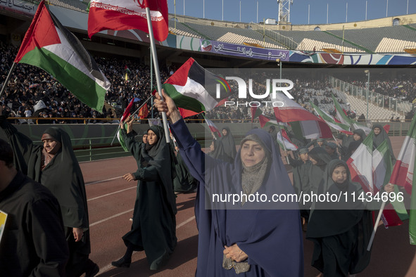 A group of veiled women is waving Iranian and Palestinian flags while performing in a family rally to support mandatory hijab, at the Azadi...