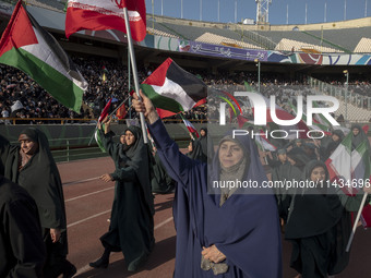 A group of veiled women is waving Iranian and Palestinian flags while performing in a family rally to support mandatory hijab, at the Azadi...