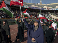 A group of veiled women is waving Iranian and Palestinian flags while performing in a family rally to support mandatory hijab, at the Azadi...