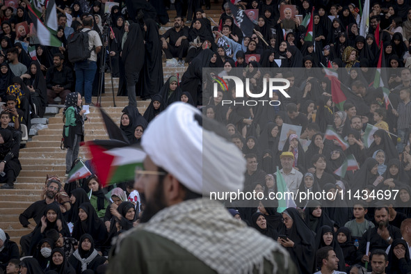 An Iranian cleric is looking at veiled women who are participating in a family rally to support mandatory hijab, at the Azadi (Freedom) Stad...