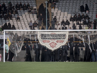 A religious flag is hanging on a soccer goal, while veiled Iranian women are participating in a family rally to support mandatory hijab, at...