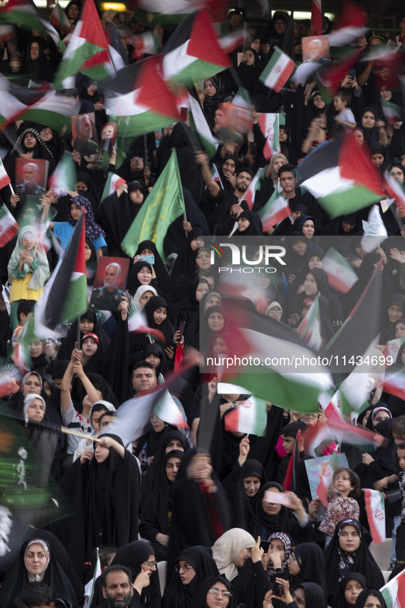 Veiled Iranian women and their families are waving Palestinian flags while participating in a family rally to support mandatory hijab at the...